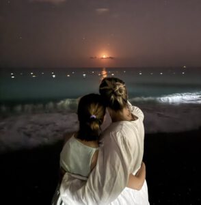 Stephie und Ida stehen gemeinsam am Strand und schauen in den Nachthimmel.